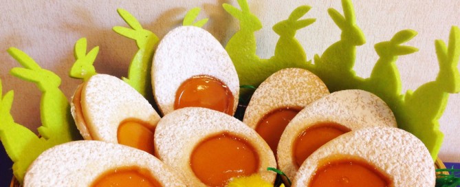 Bunte Mürbeteig-Ostereier mit Zuckerguss und bunten Streuseln dekoriert